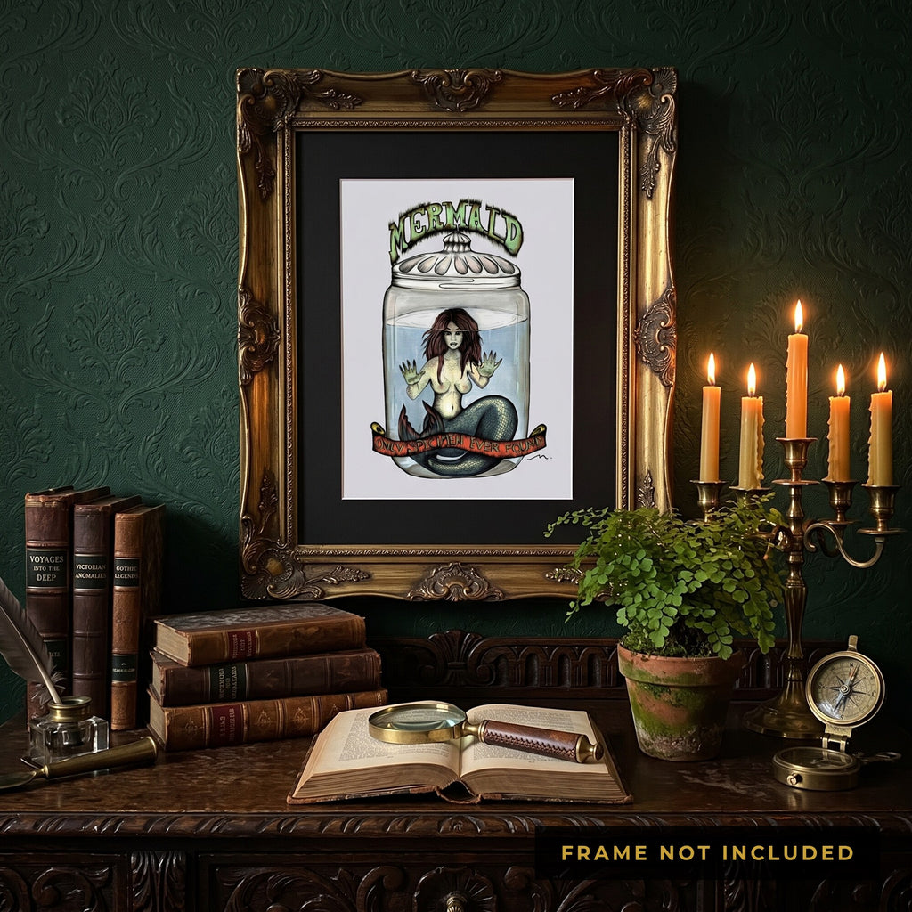 The Fiji Mermaid print framed above a desk of candles and antique books