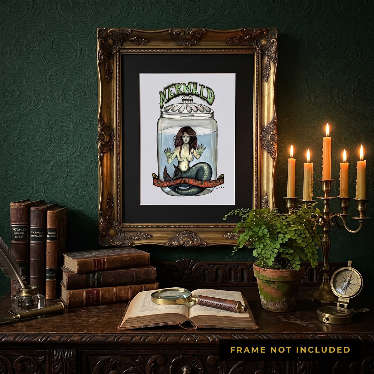 The Fiji Mermaid print framed above a desk of candles and antique books