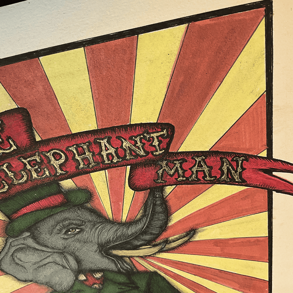 Close-up of the hand-lettered ELEPHANT MAN ribbon over the drawn sunburst