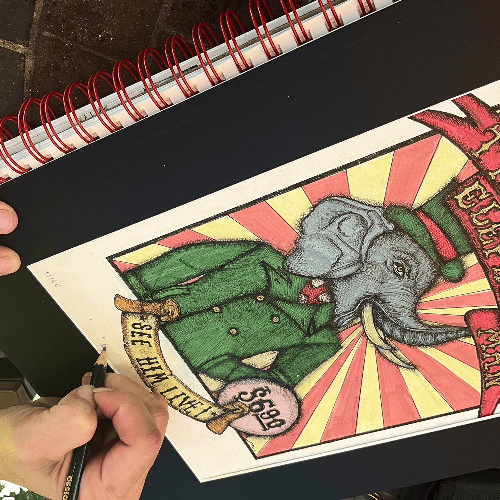The Elephant Man drawing being worked by hand in a spiral-bound sketchbook