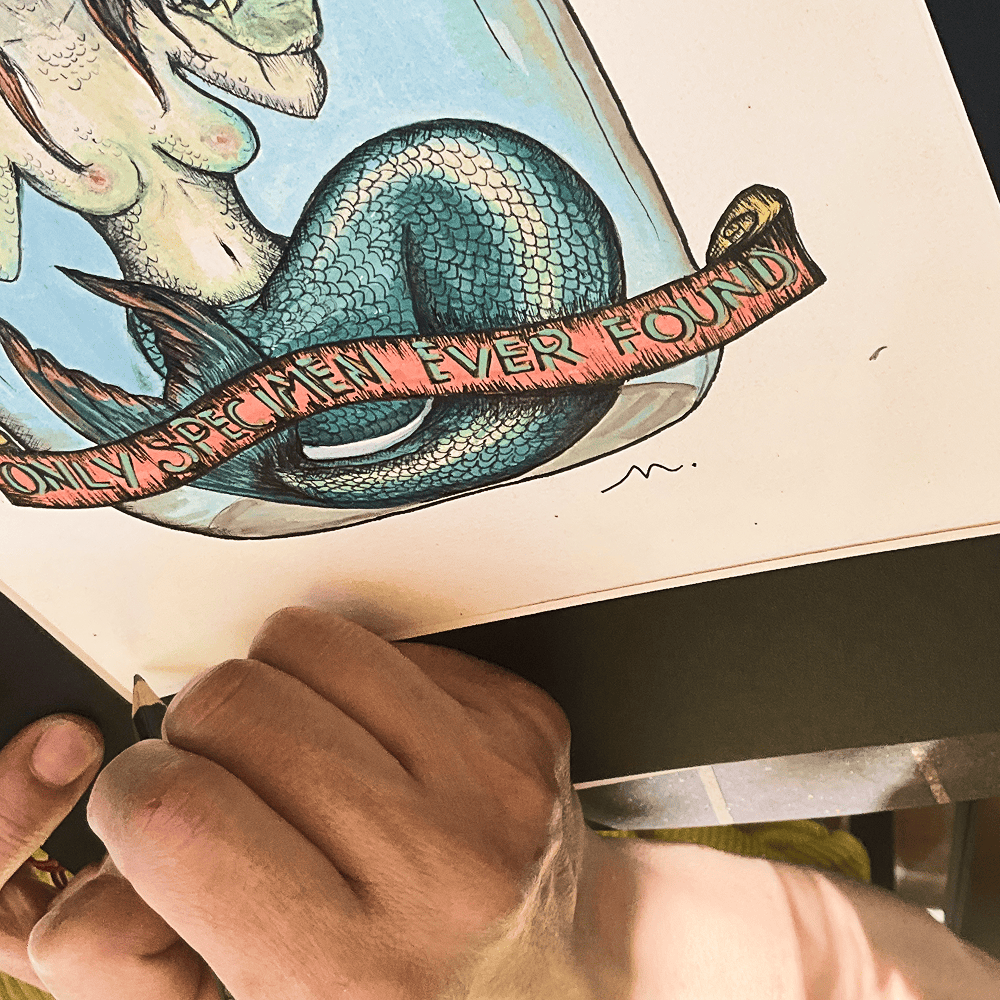 Close-up of the hand-lettered ONLY SPECIMEN EVER FOUND banner across the mermaid's tail
