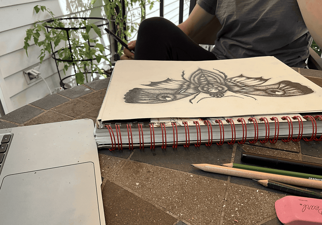 Maria Keller drawing the death's head moth at her worktable