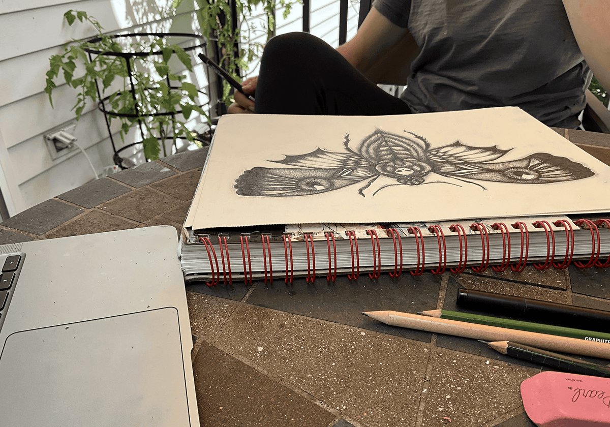Maria Keller drawing the death's head moth at her worktable